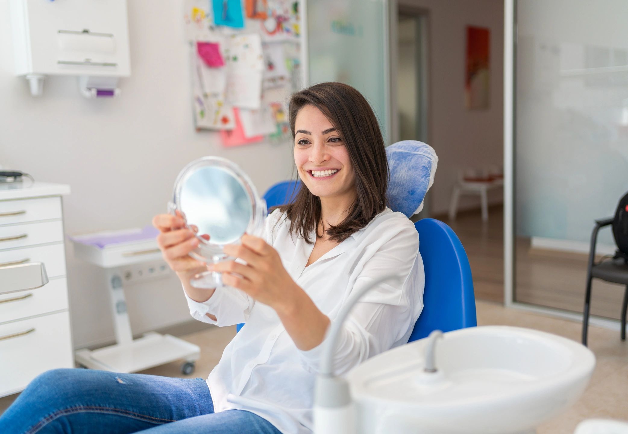Patient smiling in a dental office mirror