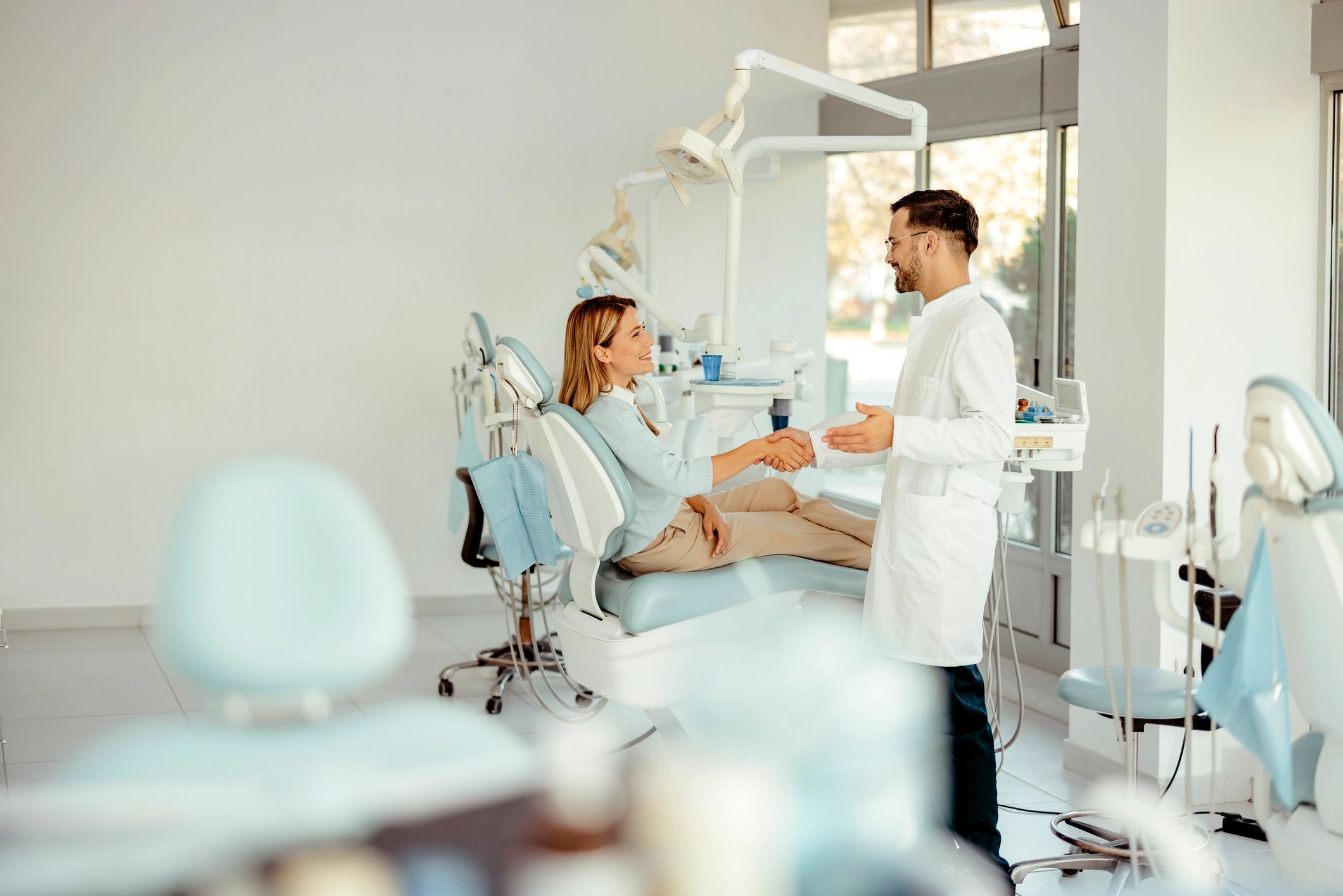 Dentist greeting a patient in a modern clinic